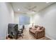 Comfortable bedroom with wood-look tile flooring, a ceiling fan, and a cozy seating area at 27158 W Potter Dr, Buckeye, AZ 85396