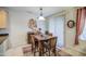 Cozy dining area with a wooden table, four chairs, and a decorative light fixture at 27158 W Potter Dr, Buckeye, AZ 85396