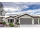 Inviting single-story home featuring a neat front yard, two-car garage, and desert landscaping at 27158 W Potter Dr, Buckeye, AZ 85396