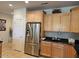 This kitchen showcases light wood cabinetry, stainless steel refrigerator, and black granite countertops at 27158 W Potter Dr, Buckeye, AZ 85396