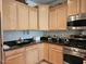 Well-lit kitchen featuring light wood cabinets, black granite countertops, and stainless steel appliances at 27158 W Potter Dr, Buckeye, AZ 85396