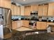 Spacious kitchen featuring light wood cabinets, stainless steel appliances, and black granite countertops at 27158 W Potter Dr, Buckeye, AZ 85396