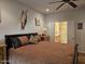 Comfortable main bedroom boasts a king-size bed, ceiling fan, and en-suite bathroom access for convenience at 27158 W Potter Dr, Buckeye, AZ 85396
