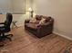 Comfortable home office features stylish wood flooring, sofa and a modern chair perfect for work or relaxation at 27158 W Potter Dr, Buckeye, AZ 85396