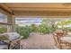Charming covered patio with a built-in grill, dining set, and lush landscaping at 27158 W Potter Dr, Buckeye, AZ 85396