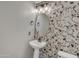 The bathroom has a decorative stone accent wall, oval mirror, and pedestal sink at 3076 E Dunbar Dr, Phoenix, AZ 85042