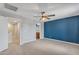 This primary bedroom features carpet flooring, blue accent wall, and ceiling fan at 3076 E Dunbar Dr, Phoenix, AZ 85042