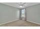 This bedroom has a ceiling fan, carpet flooring and a window overlooking the backyard at 3076 E Dunbar Dr, Phoenix, AZ 85042