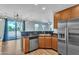 Open kitchen features stainless steel appliances, wood cabinets, a breakfast bar, and an adjoining living room at 3076 E Dunbar Dr, Phoenix, AZ 85042