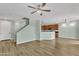 Open living space boasts wood laminate floors, a ceiling fan, and adjacent kitchen area at 3076 E Dunbar Dr, Phoenix, AZ 85042