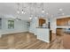 Spacious living area with hardwood laminate floors, kitchen island, and contemporary lighting at 3076 E Dunbar Dr, Phoenix, AZ 85042