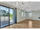 Bright living space features laminate floors, modern lighting fixture, and a sliding glass door to the patio at 3076 E Dunbar Dr, Phoenix, AZ 85042