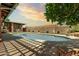 Private pool area with a tall block fence, manicured synthetic lawn, and shady trees at 3248 E Windrose Dr, Phoenix, AZ 85032