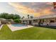Inviting backyard with pool, manicured lawn, fountain, and covered patio space at 3248 E Windrose Dr, Phoenix, AZ 85032