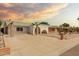 View of the home's front exterior showcases its white facade, brick accents, and low-maintenance desert landscaping at 3248 E Windrose Dr, Phoenix, AZ 85032