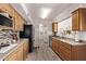 Galley-style kitchen with wood cabinets, stainless steel appliances, and durable granite countertops at 3248 E Windrose Dr, Phoenix, AZ 85032