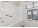 Clean white bath and shower space featuring tile-style flooring at 3300 N Coronado St, Chandler, AZ 85224
