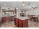 Open-concept kitchen and dining area with an island, stainless steel appliances, and a brick fireplace at 3300 N Coronado St, Chandler, AZ 85224
