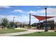 Community playground showcasing a covered picnic area, benches, lush green grass, and safe recreational facilities at 4050 E Brittlebush Ln, San Tan Valley, AZ 85140
