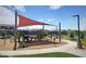 Community playground featuring modern play structures, shade canopies, benches and a sidewalk for easy access and recreation at 4050 E Brittlebush Ln, San Tan Valley, AZ 85140