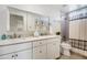 Bright bathroom with a double sink vanity, a large mirror, and a shower with gray tile and a striped curtain at 4809 E Red Range Way, Cave Creek, AZ 85331
