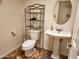 Cozy bathroom featuring a pedestal sink, oval mirror, and a storage shelf above the toilet at 520 S Evergreen Rd, Tempe, AZ 85288