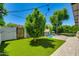 Private backyard with playhouse and artificial grass and mature trees, ideal for outdoor activities at 5425 E Avalon Dr, Phoenix, AZ 85018