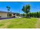 Expansive backyard featuring a covered patio, lush green lawn, mature trees, and play area at 5425 E Avalon Dr, Phoenix, AZ 85018