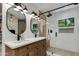 Elegant bathroom with a double sink vanity, stylish mirrors, lighting, and a glass enclosed shower with dual shower heads at 5425 E Avalon Dr, Phoenix, AZ 85018