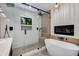 Beautiful bathroom featuring a glass-enclosed shower, a soaking tub, wood grain accents, and modern black fixtures at 5425 E Avalon Dr, Phoenix, AZ 85018