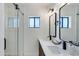 Modern bathroom with dual vanity, black fixtures, and tiled walk-in shower with glass door at 5425 E Avalon Dr, Phoenix, AZ 85018