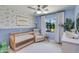 Cozy Bedroom featuring a crib, recliner, and blue walls decorated with elephant and giraffe wallpaper at 5425 E Avalon Dr, Phoenix, AZ 85018