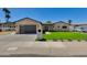 Charming single-story home featuring brick accents, lush green lawn, and modern garage door at 5425 E Avalon Dr, Phoenix, AZ 85018