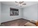 Bedroom with neutral walls, wood-look floors, a window with blinds, and a ceiling fan at 610 S St Paul --, Mesa, AZ 85206