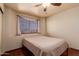 Bedroom with tan walls, window with blinds and a queen-size bed with neutral bedding at 610 S St Paul --, Mesa, AZ 85206