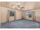 Large bedroom with blue carpet, two large windows, and ceiling fan at 610 S St Paul --, Mesa, AZ 85206