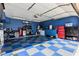 Garage with blue walls and blue-and-white checkerboard flooring, featuring storage and work space at 610 S St Paul --, Mesa, AZ 85206