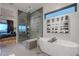 Bright bathroom with a glass shower and soaking tub. The design includes floating cabinets at 6142 E Alta Hacienda Dr, Scottsdale, AZ 85251