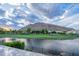 This picturesque view features a tranquil lake, a lush golf course, and a majestic mountain backdrop at 6142 E Alta Hacienda Dr, Scottsdale, AZ 85251