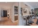 This wet bar has pendant lights above it and is adjacent to the entry hall with 3 barstools in front of it at 6142 E Alta Hacienda Dr, Scottsdale, AZ 85251