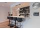 The wet bar has pendant lighting with 4 barstools in front of it and a clock on the wall at 6142 E Alta Hacienda Dr, Scottsdale, AZ 85251
