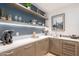 This wet bar includes shelves with decorative items, a small sink and countertop space with a built in wine cooler at 6142 E Alta Hacienda Dr, Scottsdale, AZ 85251