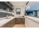 The wet bar has shelves with decorative items, a small sink and countertop space with a built in wine cooler and pendant lights at 6142 E Alta Hacienda Dr, Scottsdale, AZ 85251