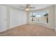 This bright bedroom features a ceiling fan, carpet, and large windows at 633 S 96Th St, Mesa, AZ 85208