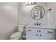 Updated half bath with white vanity, marble countertop, black hardware, and modern fixtures at 6459 E Sugarloaf St, Mesa, AZ 85215