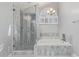 Luxurious bathroom with marble tile, a glass-enclosed shower, and a soaking tub at 6459 E Sugarloaf St, Mesa, AZ 85215