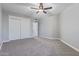 Neutral bedroom featuring a ceiling fan, soft carpet, and a large closet with white doors at 6459 E Sugarloaf St, Mesa, AZ 85215