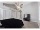Bright bedroom with soft carpet, a modern ceiling fan, and a wall-mounted television at 6459 E Sugarloaf St, Mesa, AZ 85215