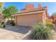 A well-maintained home featuring a two-car garage and beautiful landscaping with gravel and mature flowering bushes at 6459 E Sugarloaf St, Mesa, AZ 85215