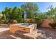 Backyard view of a hot tub with a stone-paver patio surrounded by plants and trees at 6459 E Sugarloaf St, Mesa, AZ 85215